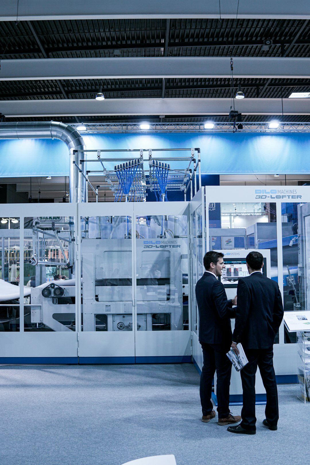 two-men-standing-in-front-of-glass-wall-zf0ngsmybok